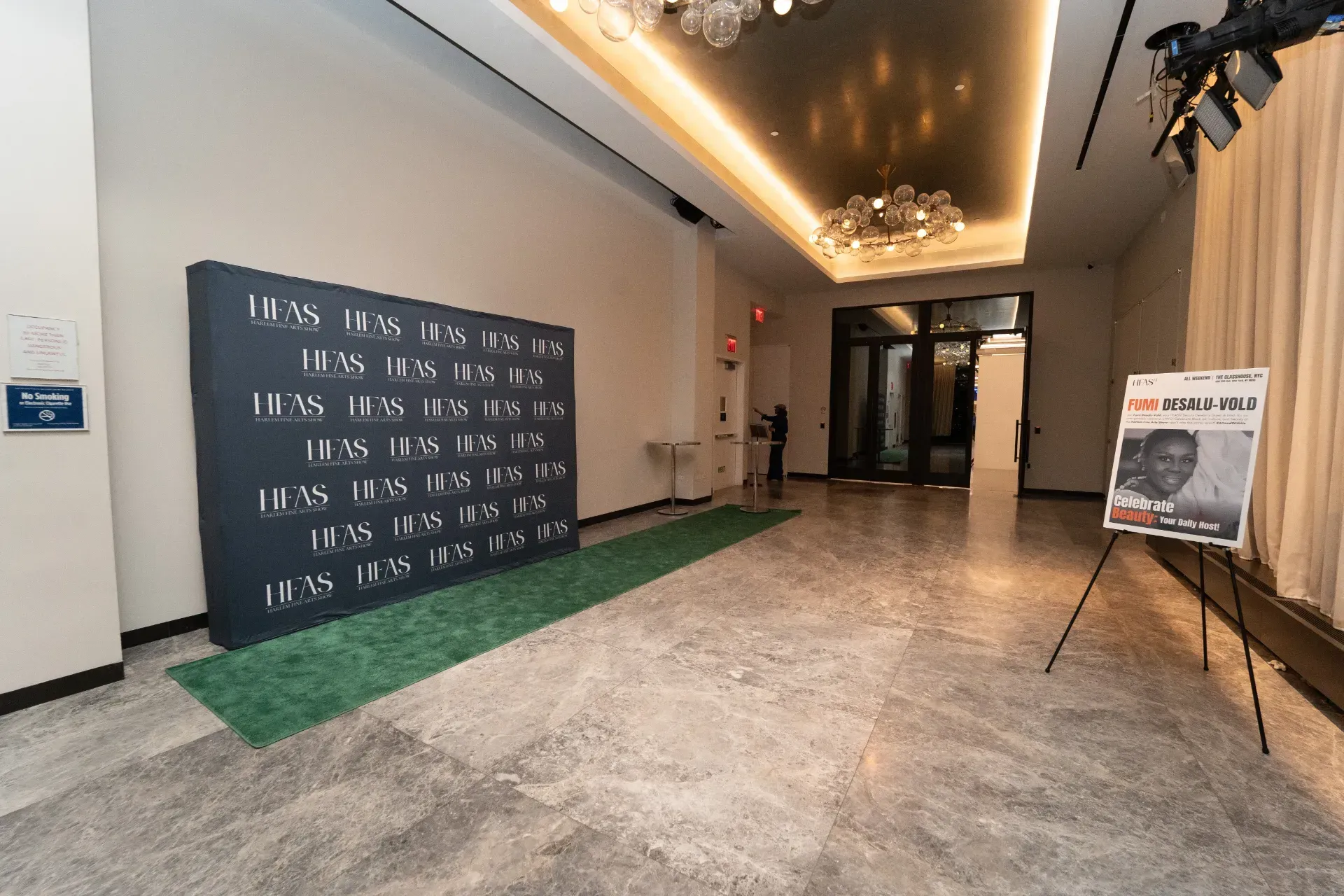 A large hallway with a sign on the wall and a picture of a man on a stand.