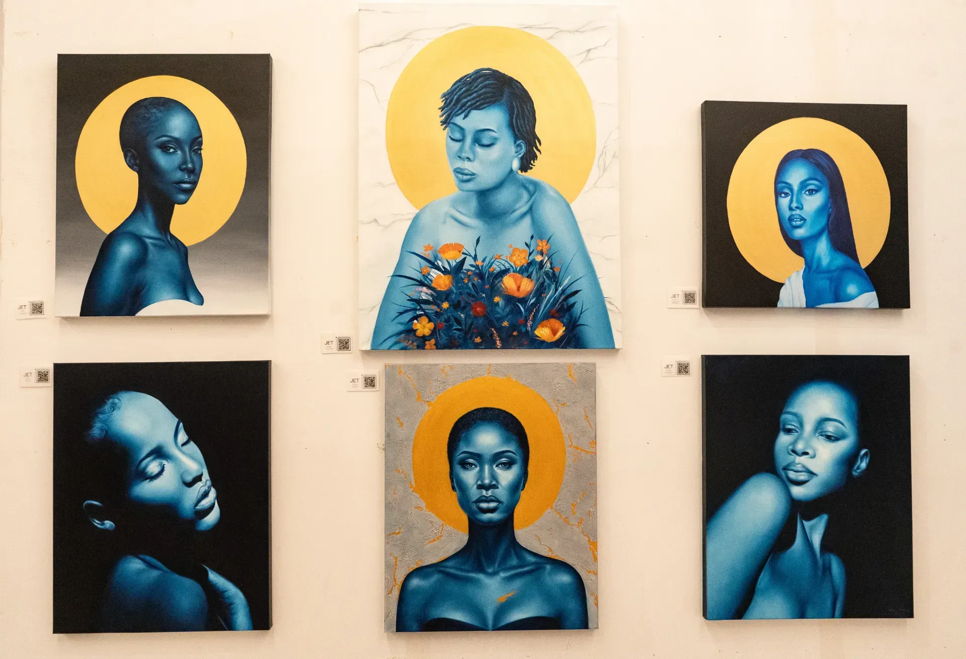 A group of paintings of a woman with a yellow halo on her head are hanging on a wall.