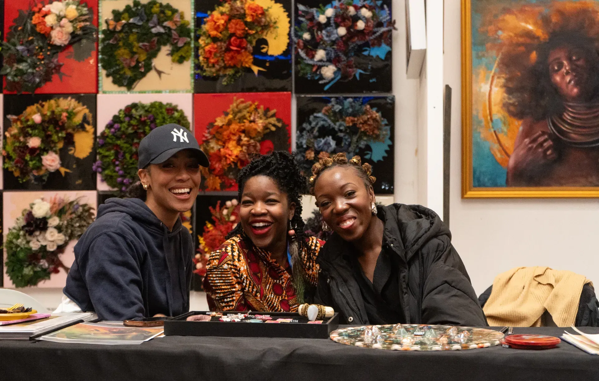 Three women are posing for a picture while sitting at a table.