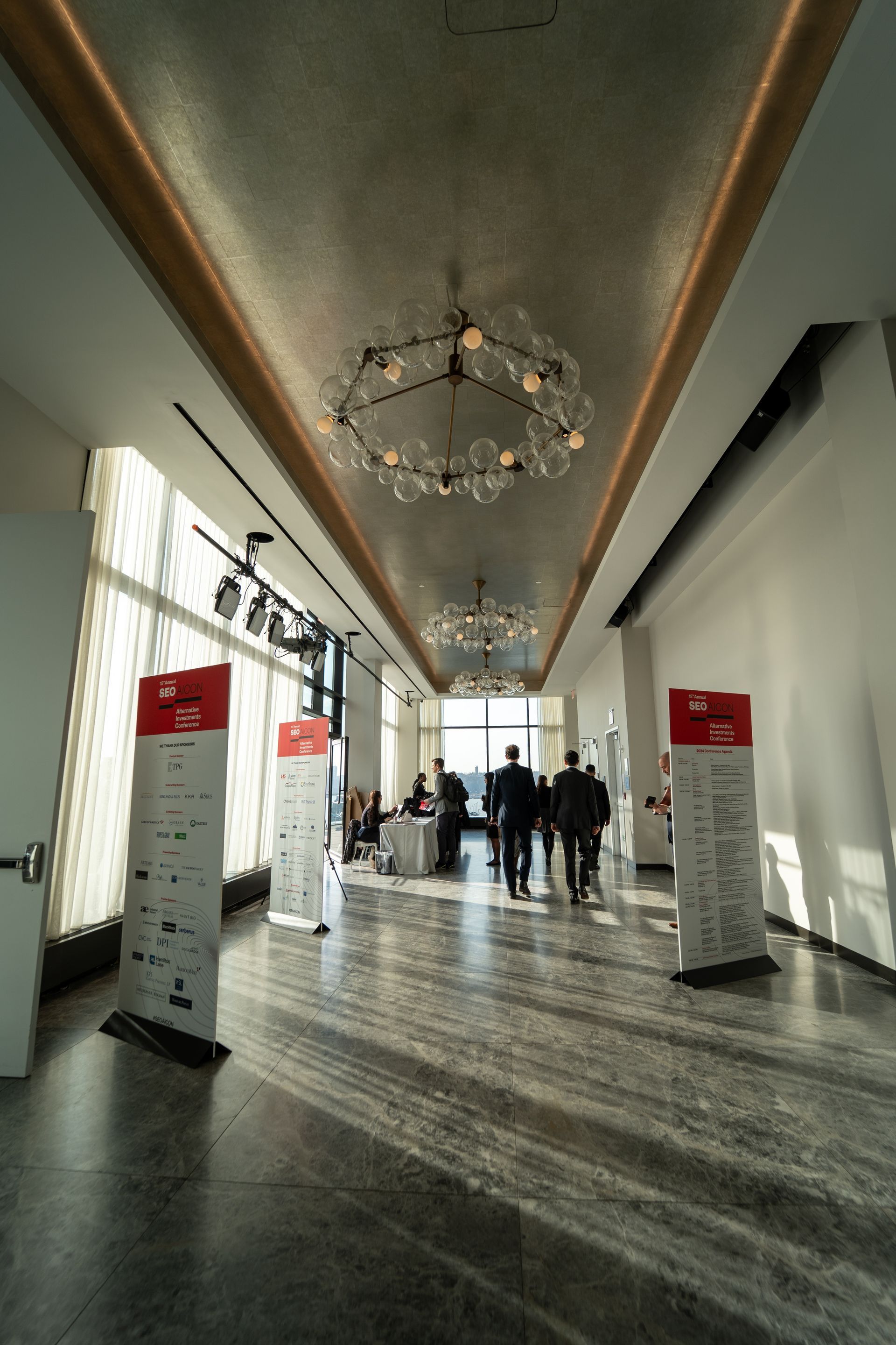 A long hallway with a chandelier hanging from the ceiling.
