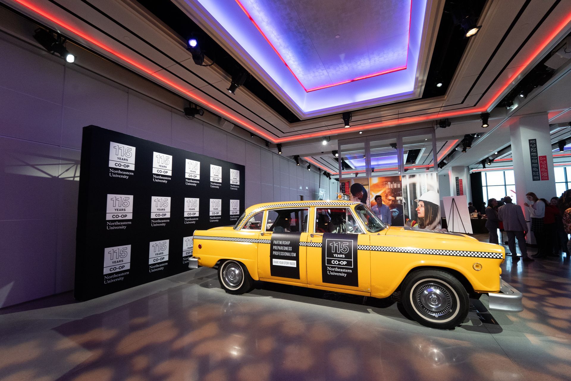 A yellow taxi cab is parked in a room with a purple ceiling.