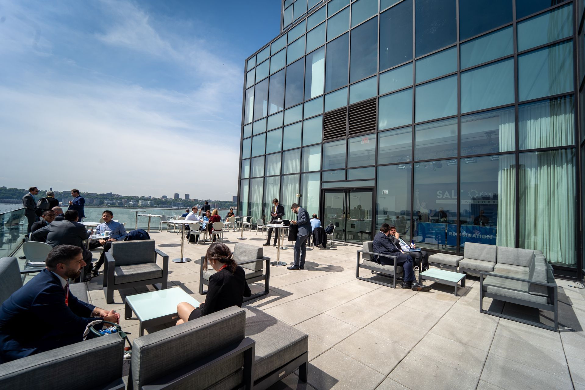 A group of people are sitting on a patio outside of a building.