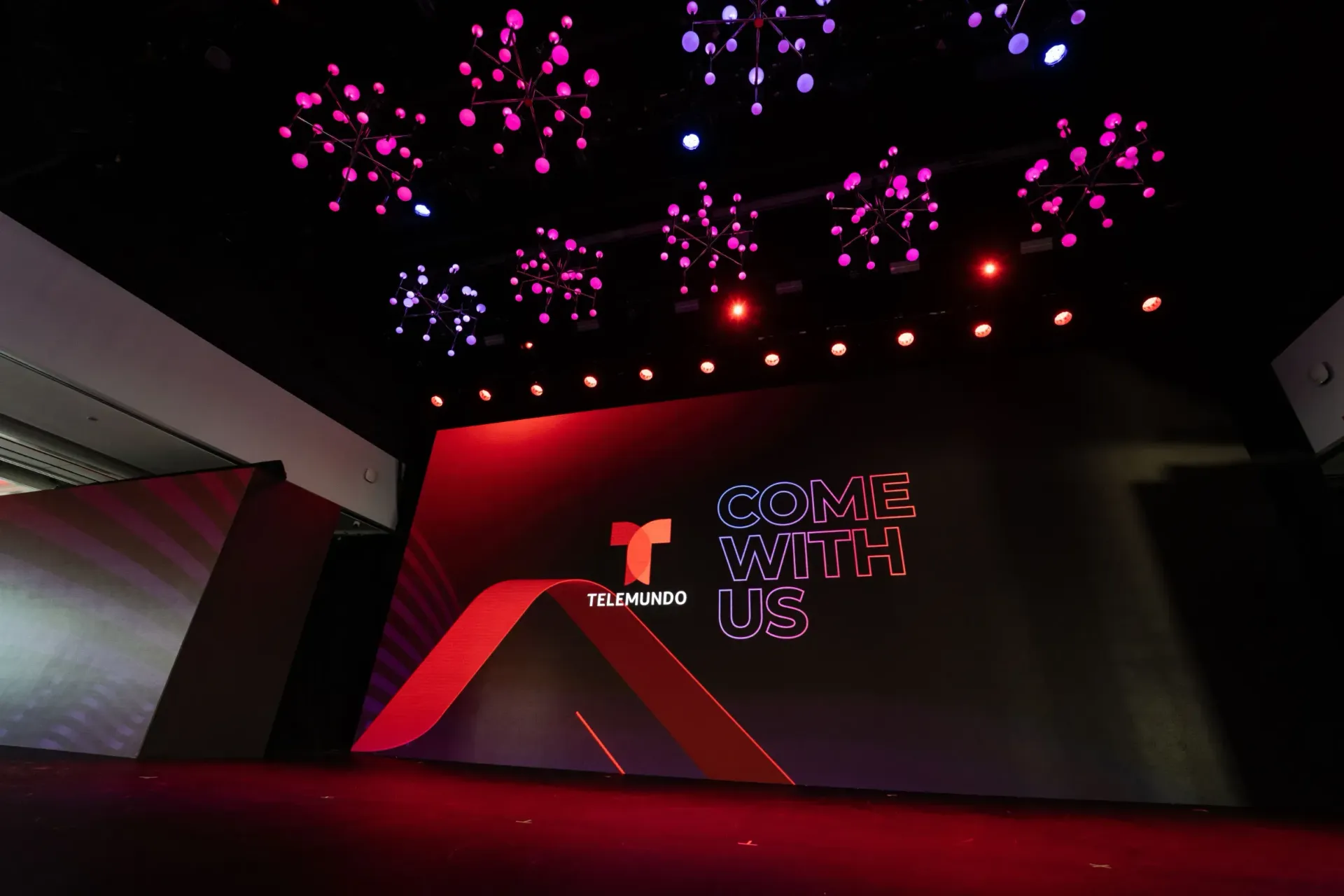 A stage with a t on it and fireworks coming out of the ceiling.