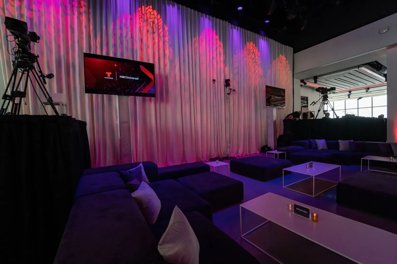 A living room with a couch and a television on the wall.