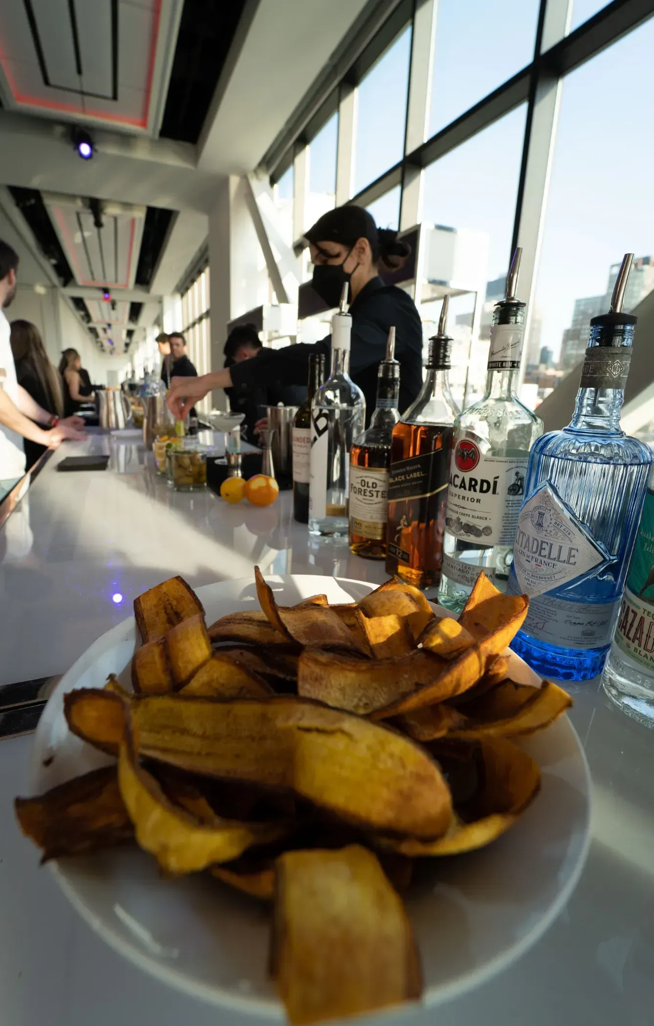 A plate of chips is sitting on a table in front of a bar.