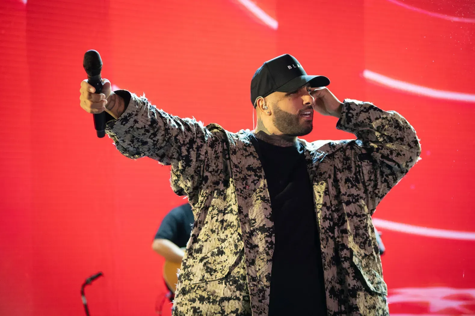 A man is singing into a microphone on a stage.