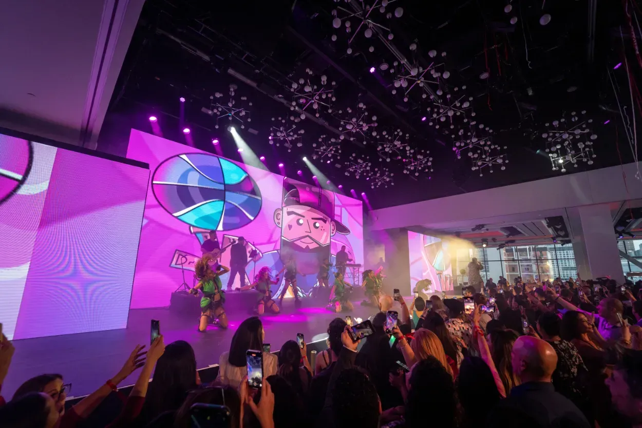 A crowd of people are standing in front of a stage at a concert.