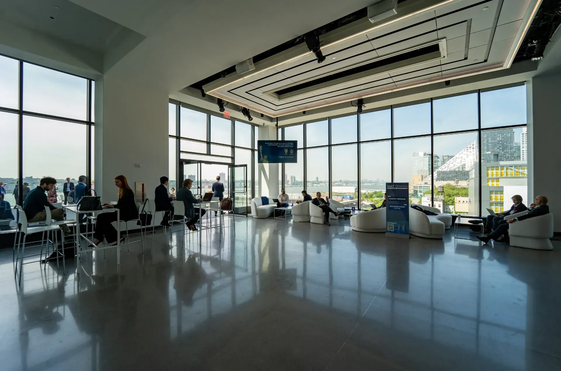 A large room with a lot of windows and people sitting at tables.