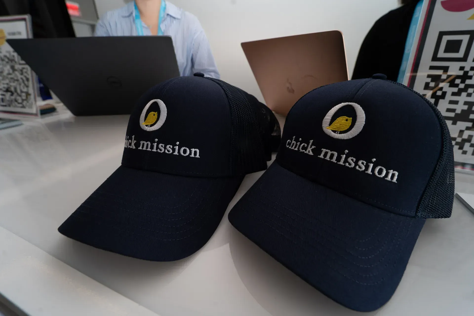 Two hats that say kick mission are on a table