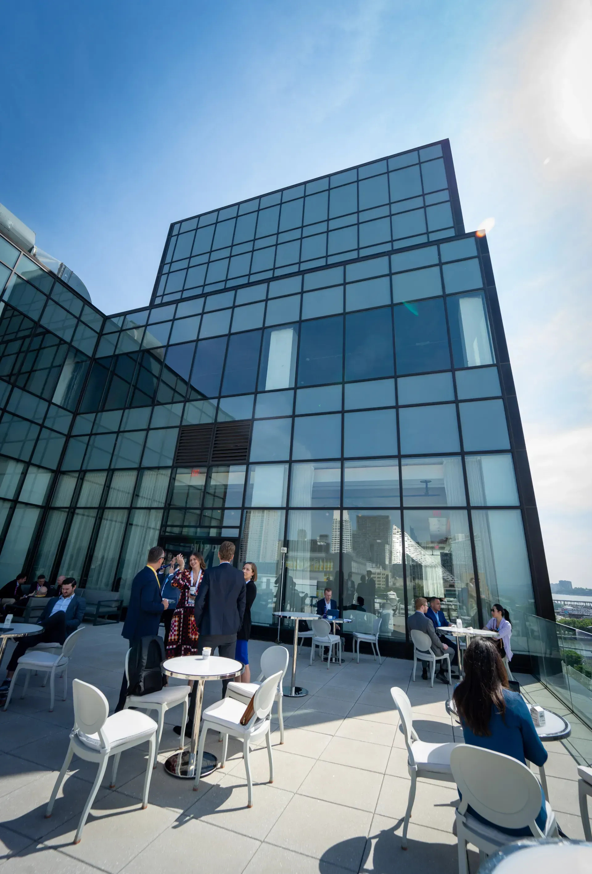 A group of people are sitting at tables outside of a building.