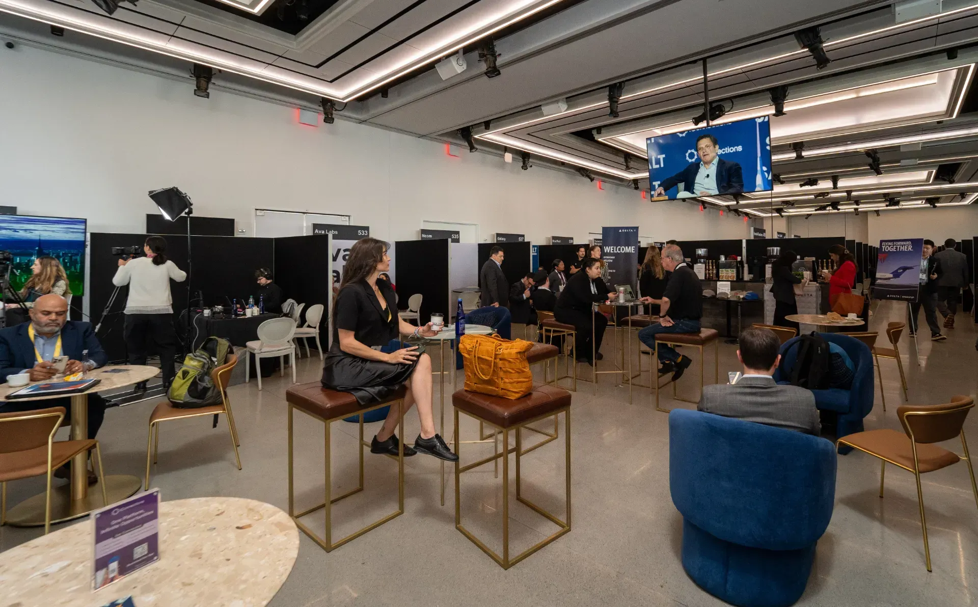 A group of people are sitting at tables in a large room.
