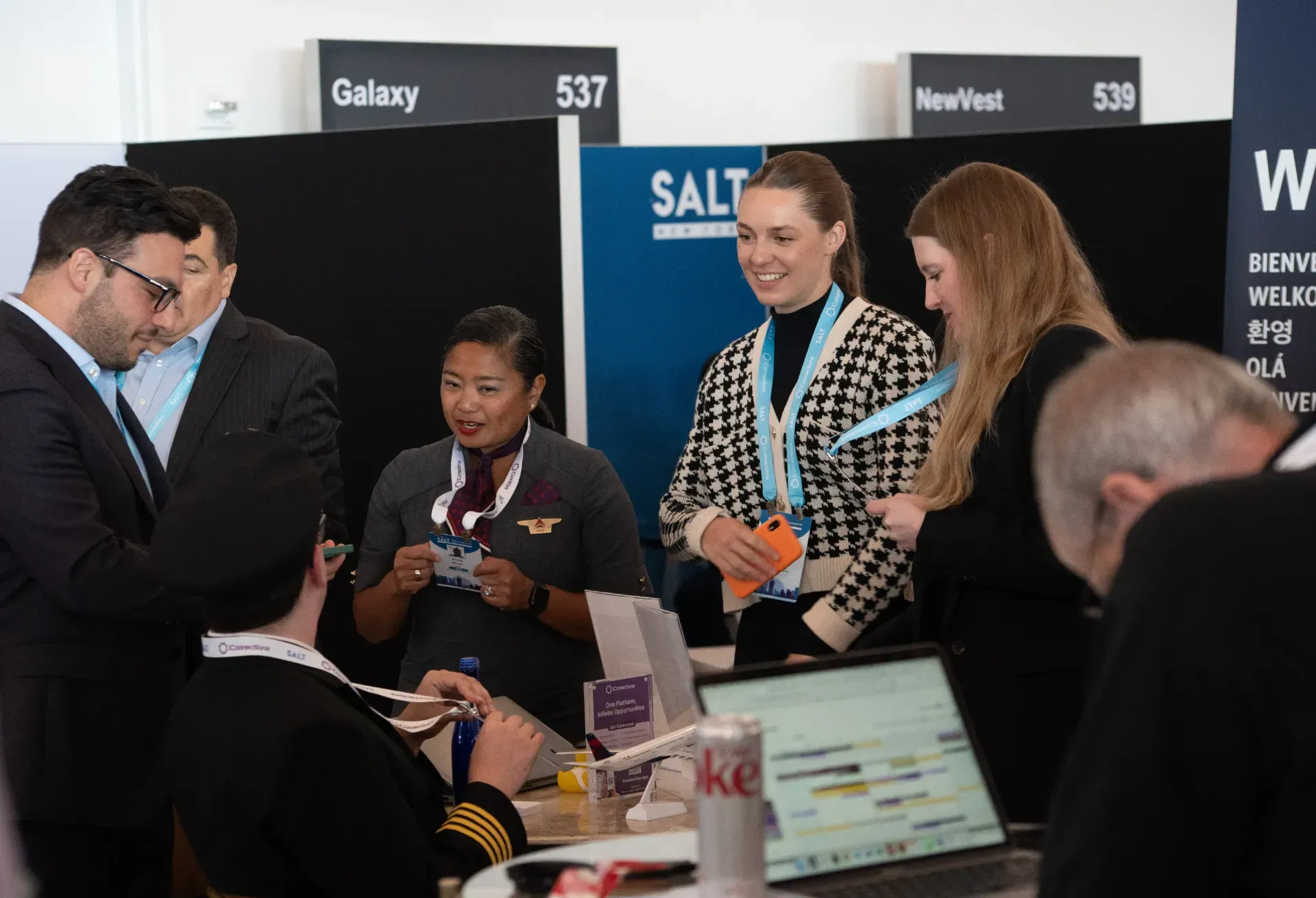 A group of people are standing around a table in front of a sign that says salt.