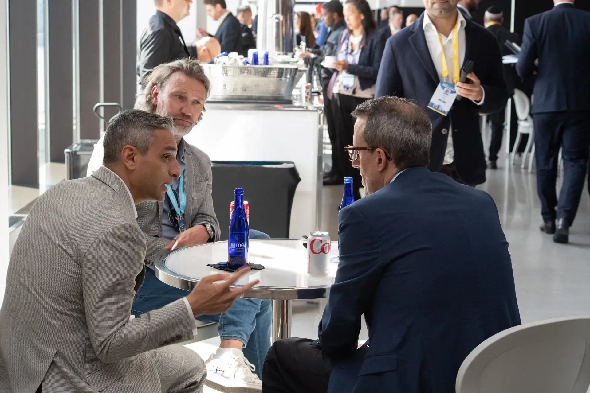 A group of men are sitting at a table talking to each other.