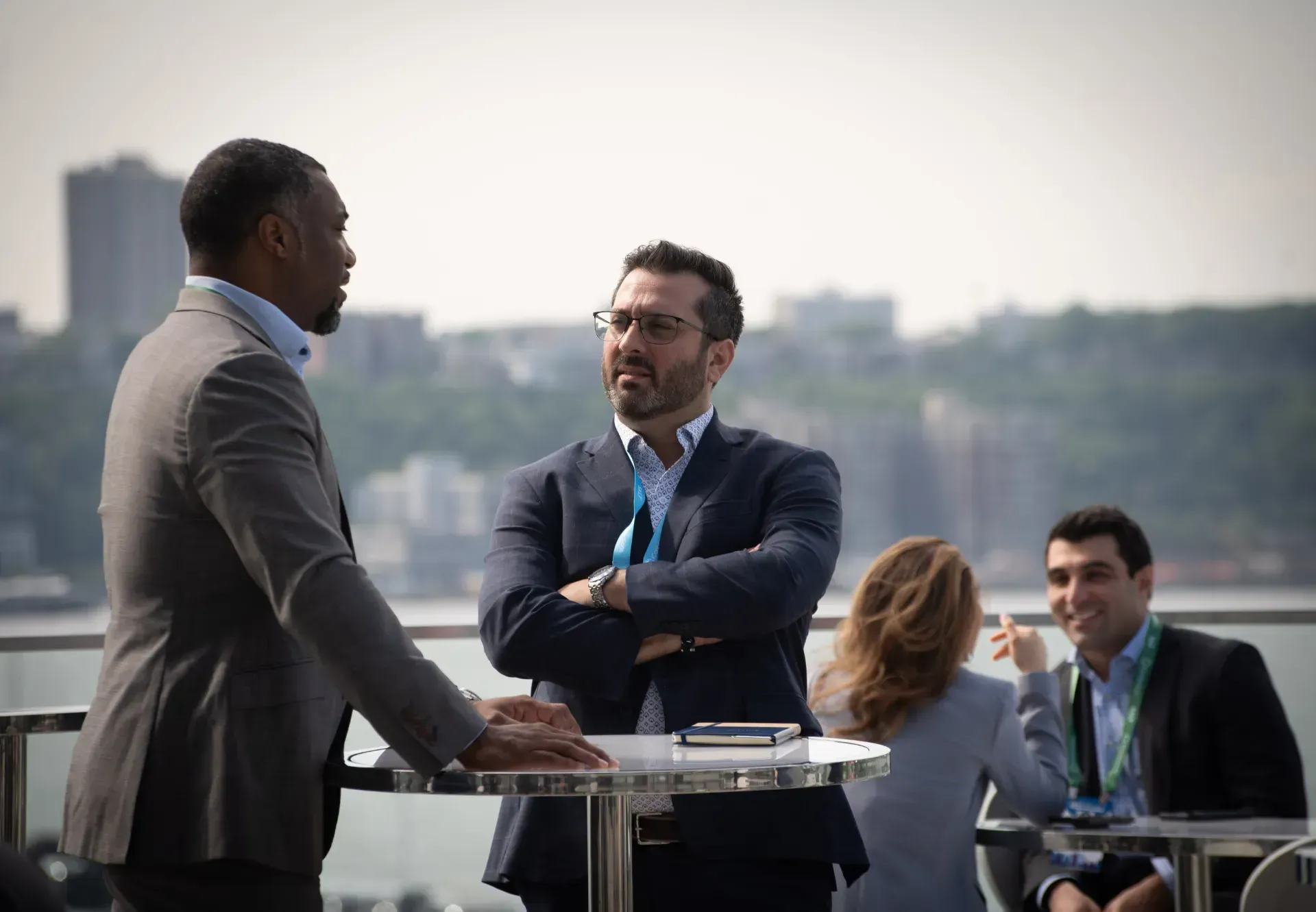 A group of people are standing around a table talking to each other.