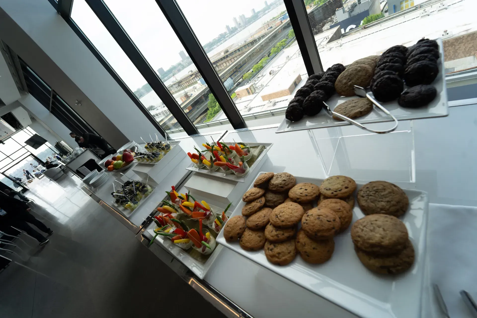 Several plates of food are on a table with a window in the background