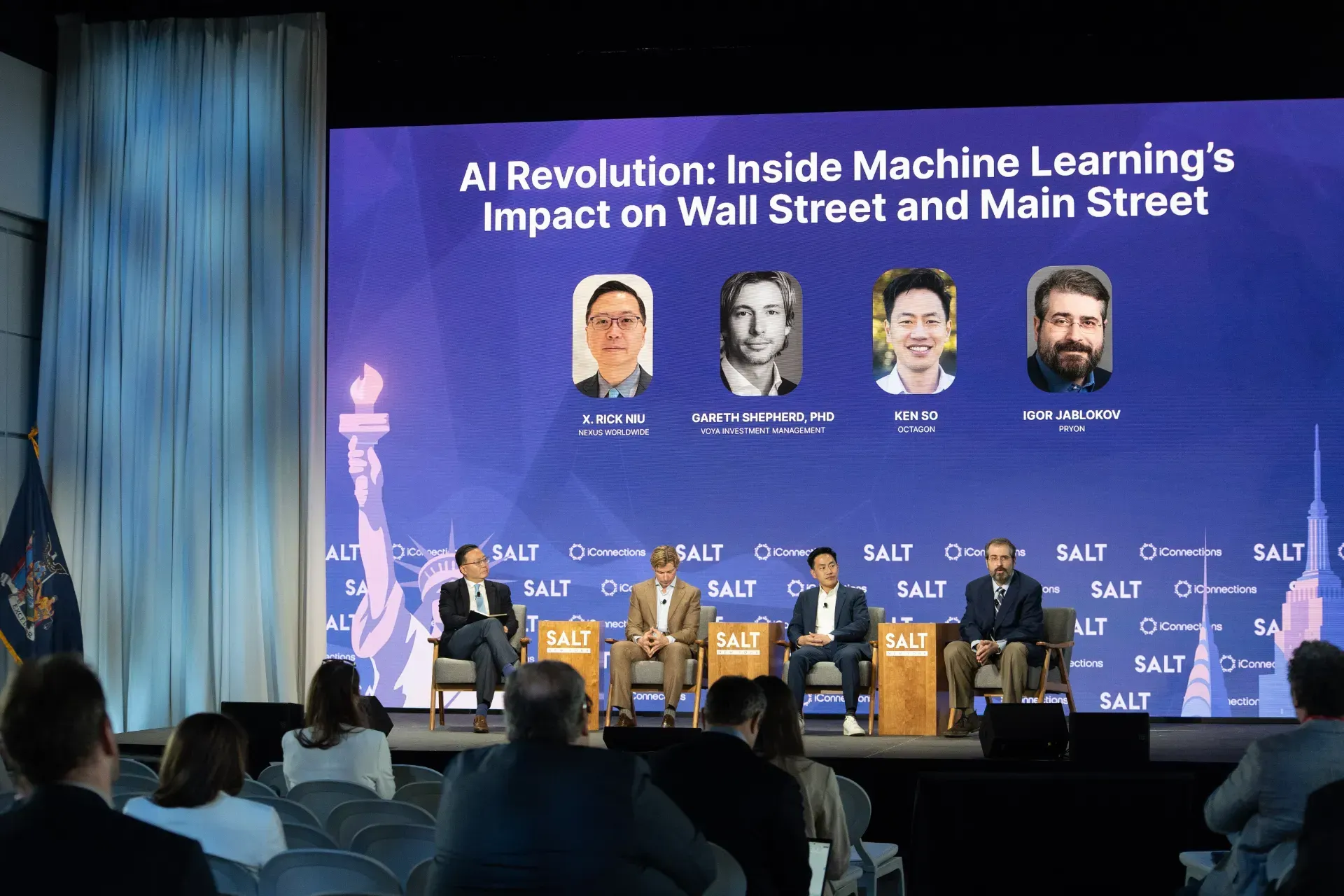 A group of people are sitting in front of a large screen