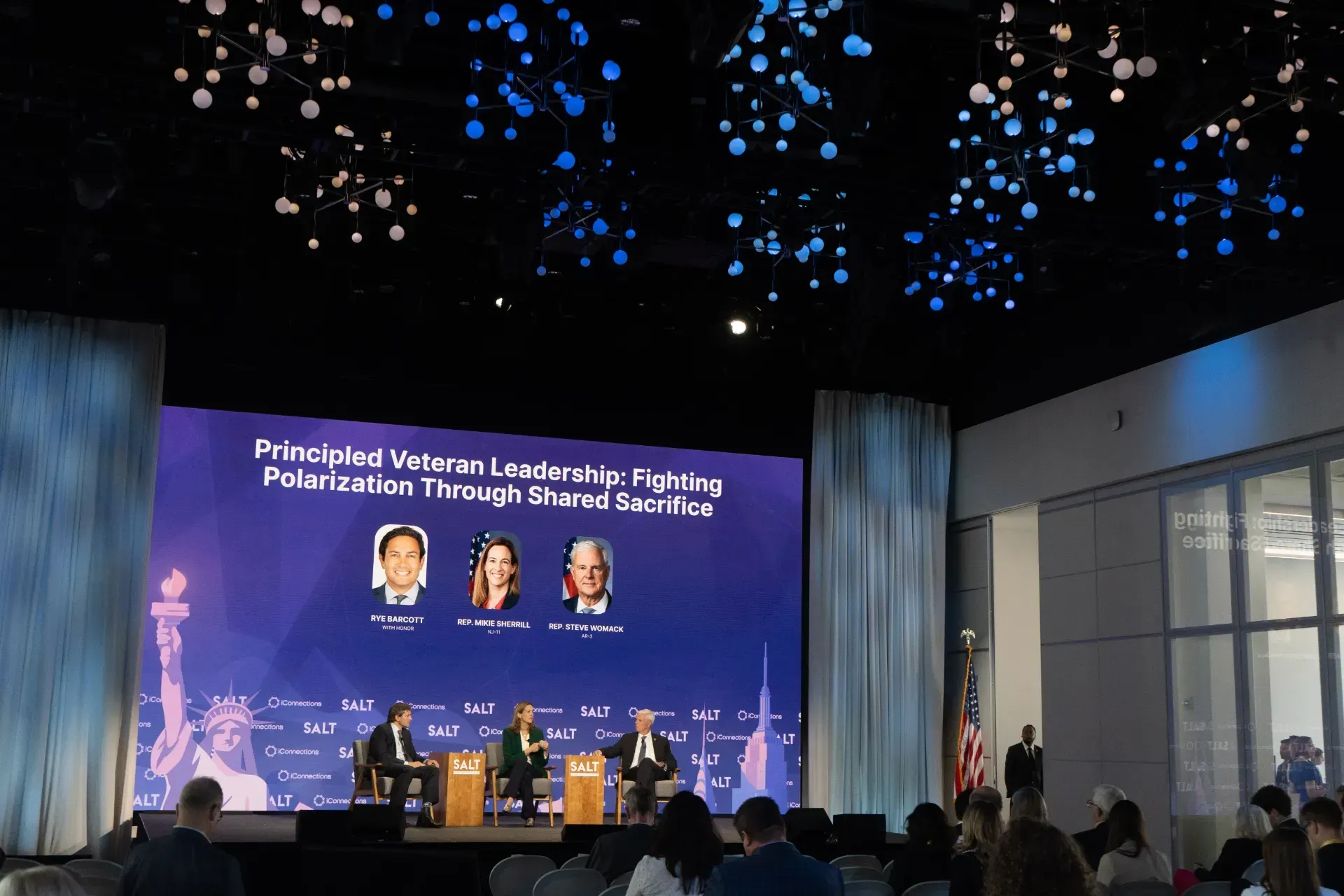 A group of people are sitting in front of a large screen.