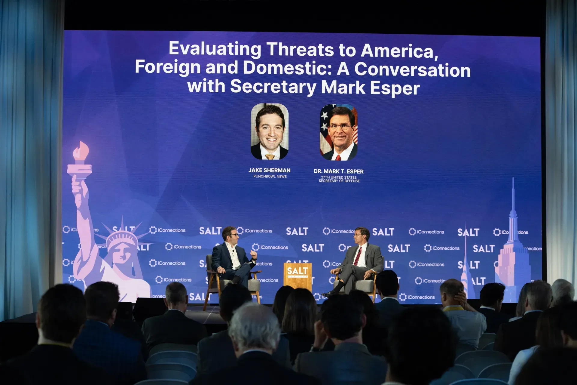 A group of people sitting in front of a screen that says evaluating threats to america foreign and domestic