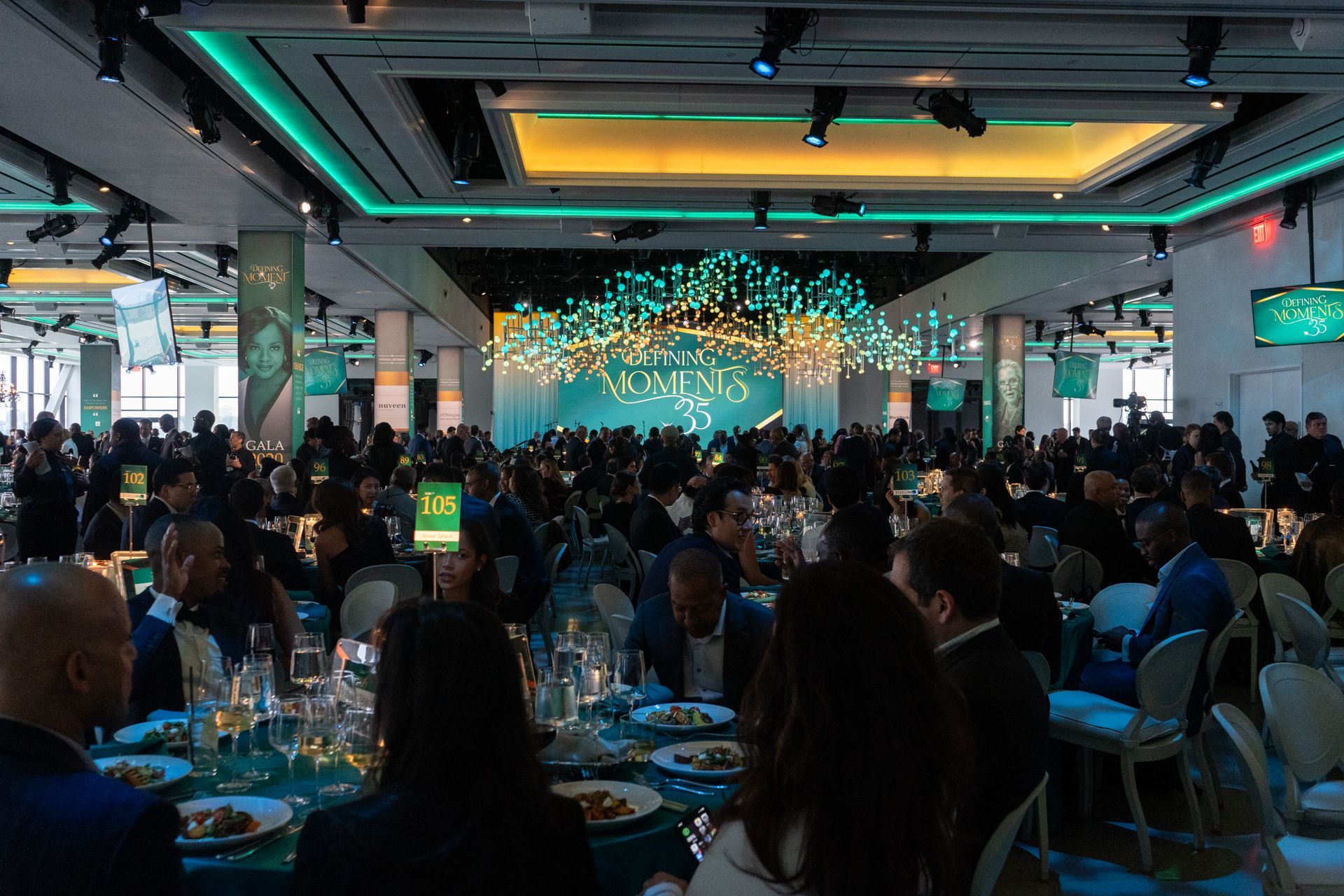 A large group of people are sitting at tables in a large room.