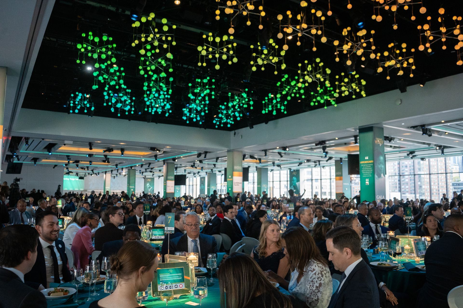 A large group of people are sitting at tables in a large room.