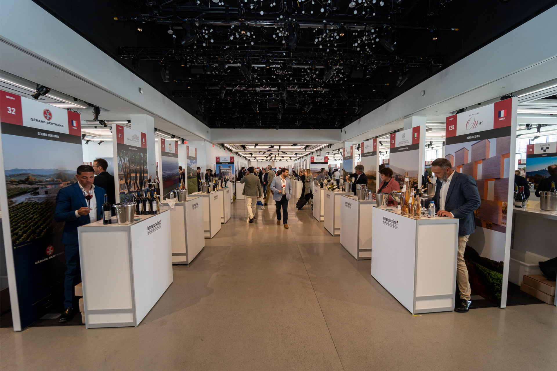 A large room filled with tables and bottles of wine.