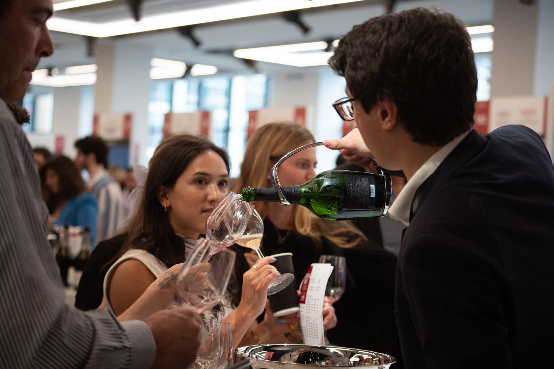 A man is pouring wine into a glass for a woman.