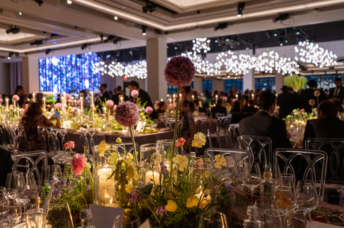 a large room filled with tables and chairs decorated with flowers and candles .