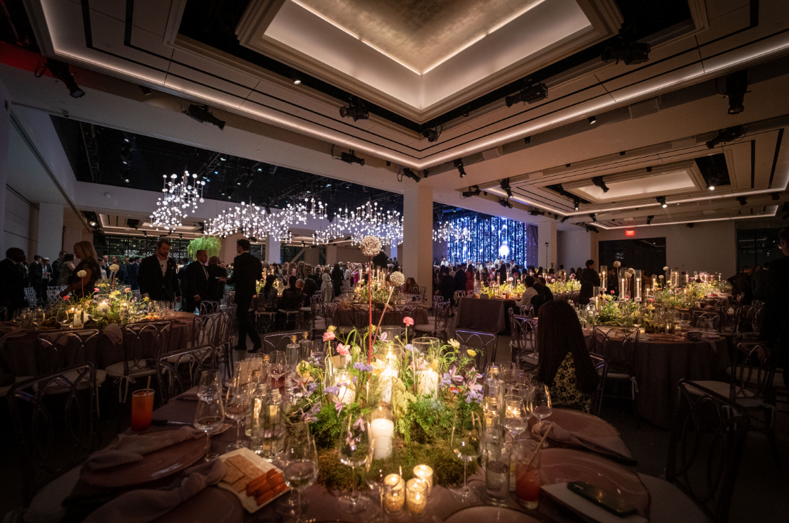 a large room filled with tables and candles at a wedding reception .
