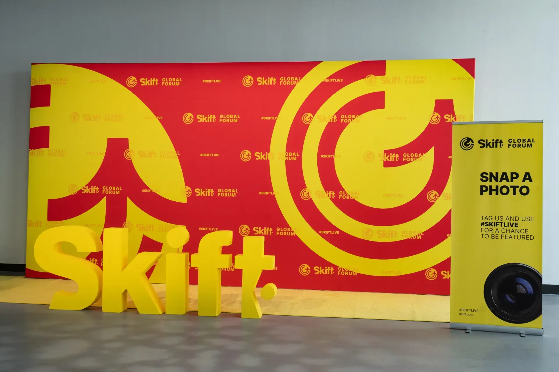 A large yellow sign that says shift is sitting next to a sign that says snap a photo.