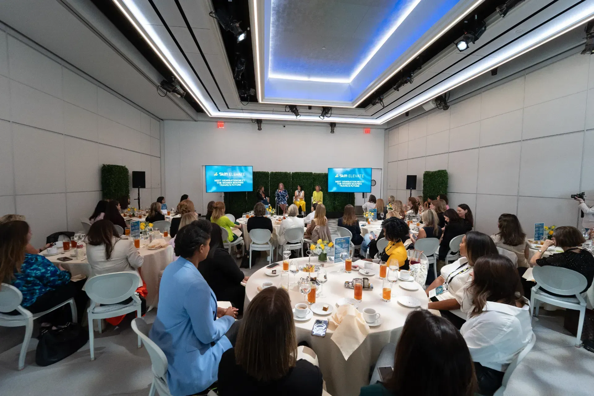A group of people are sitting at tables in a large room.
