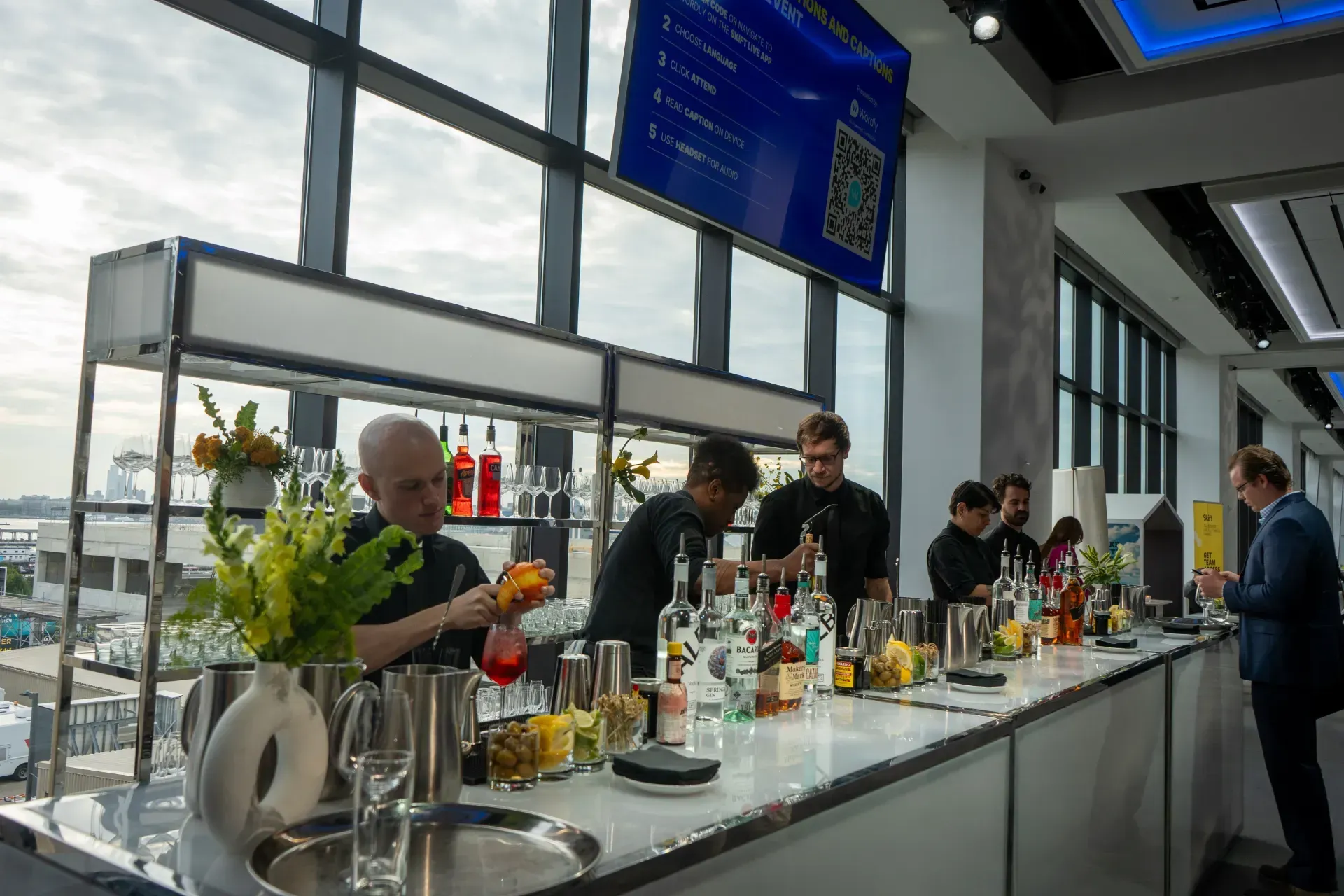 A group of people are preparing drinks at a bar.