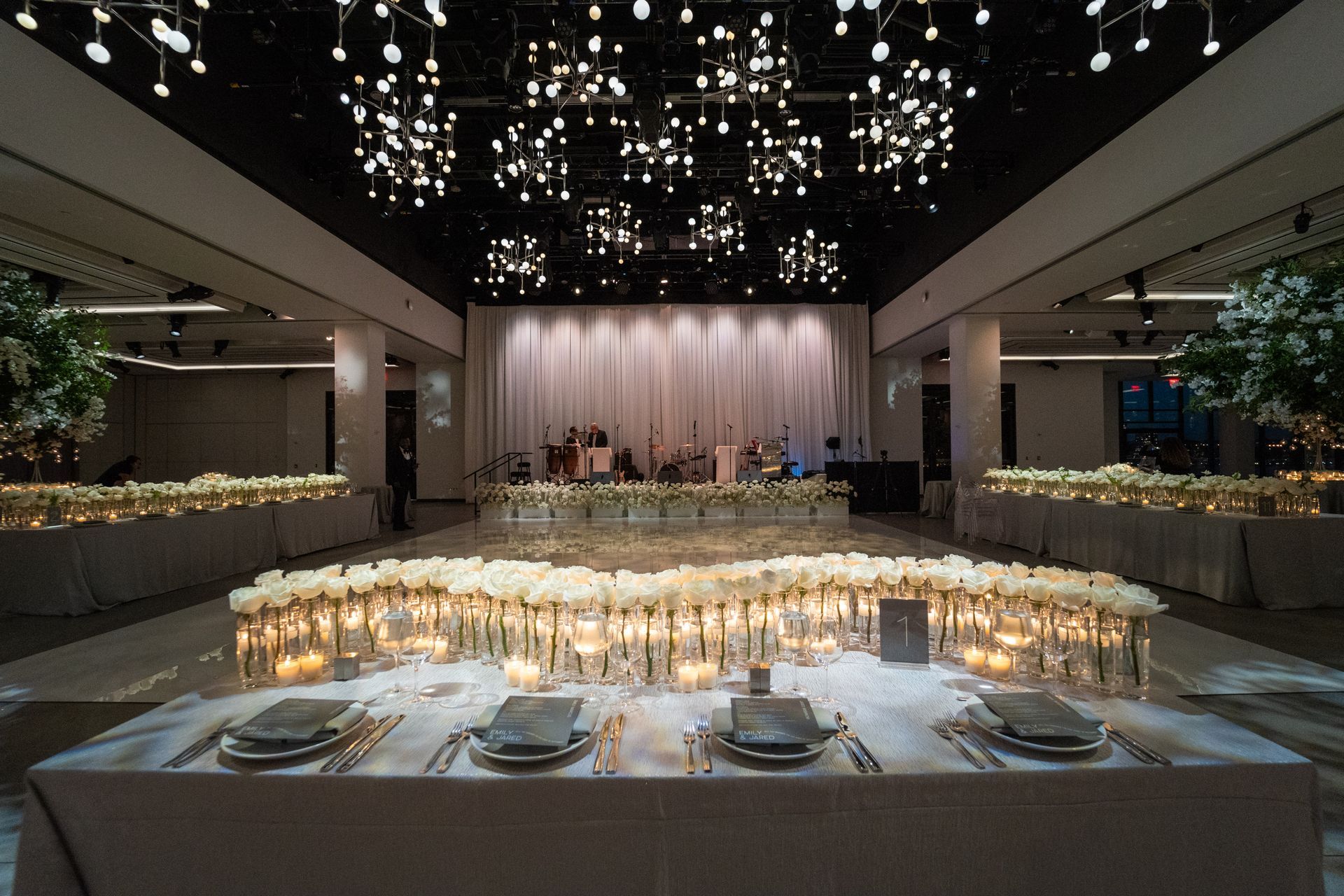 A large room with a circular dance floor and a chandelier hanging from the ceiling.