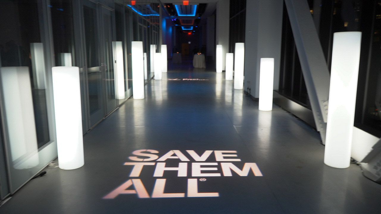 A hallway with a sign that says save them all