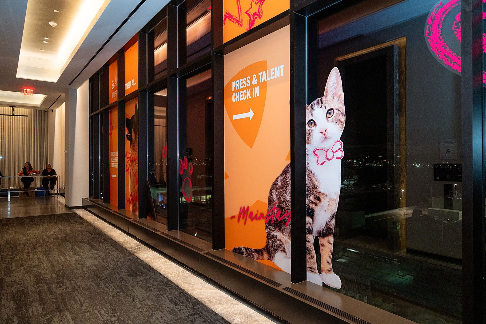 Hallway with large windows displaying a cat graphic and