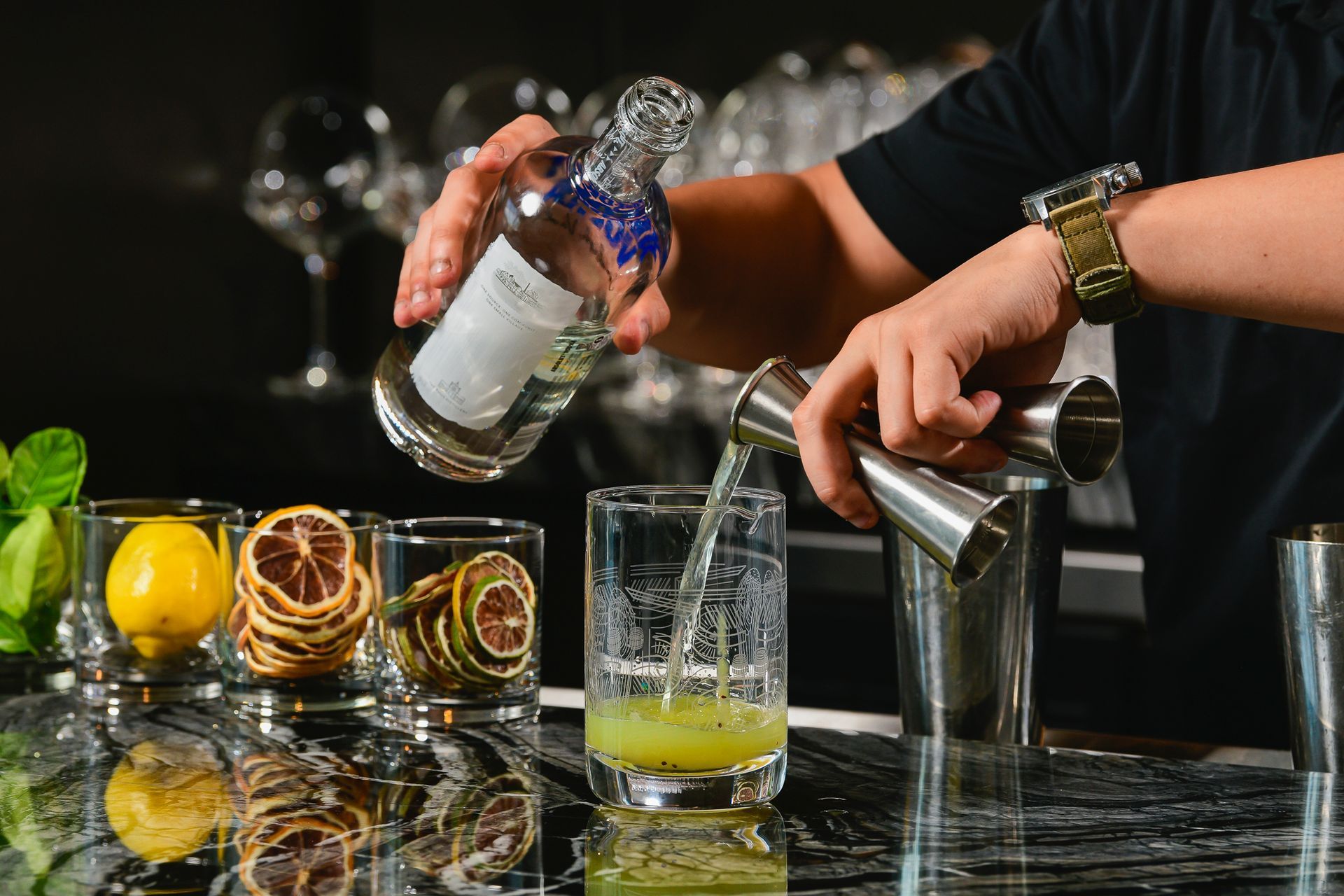 A bartender is pouring a drink into a glass.