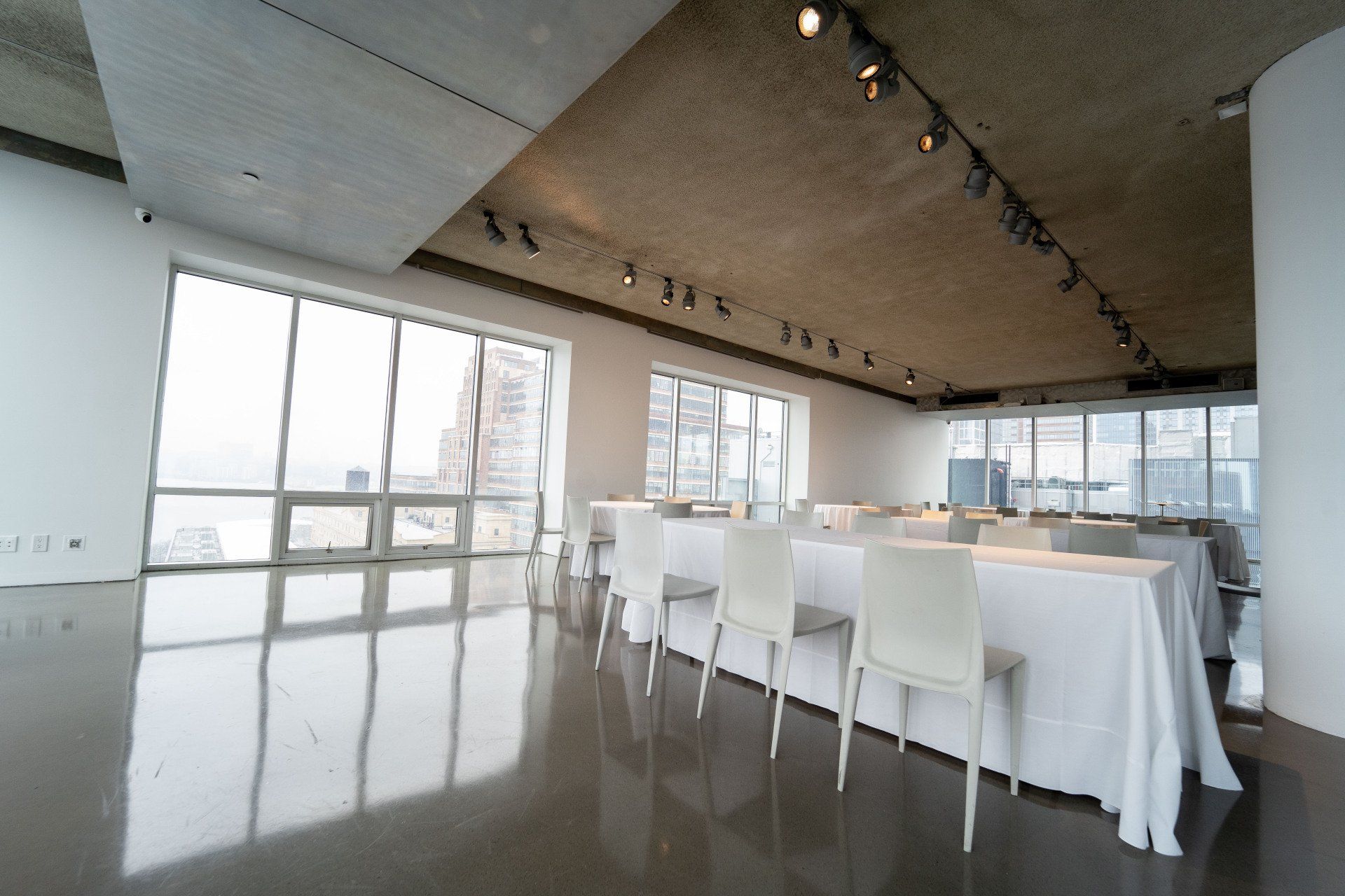 A large room with tables and chairs and lots of windows