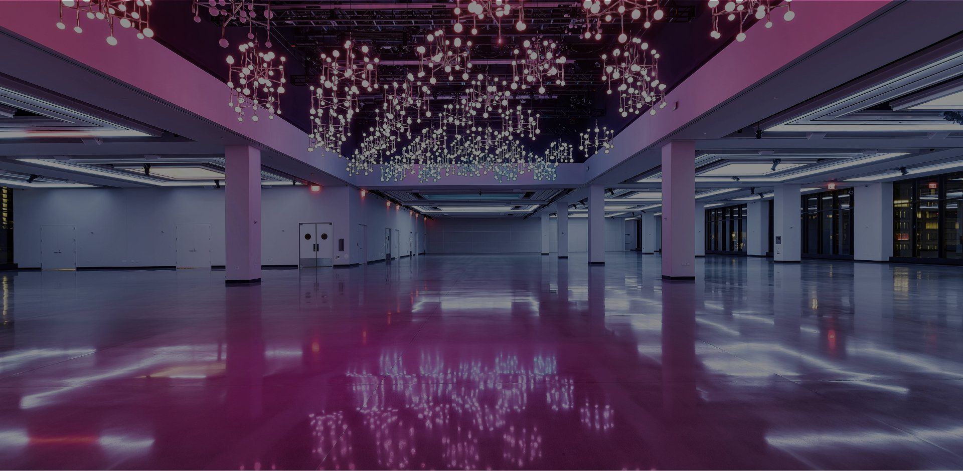 A large empty room with purple lights on the ceiling.