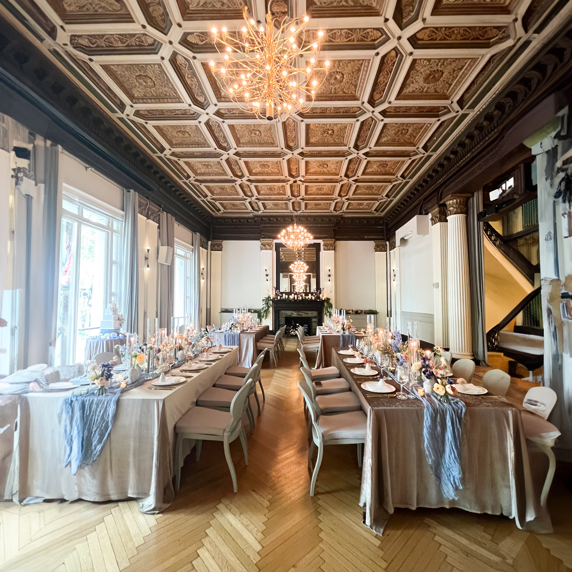 A long room with tables and chairs and a chandelier