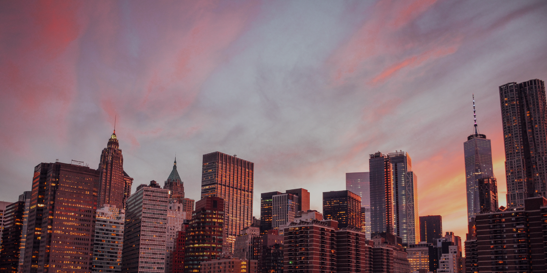 a city skyline at sunset with a pink sky in the background .