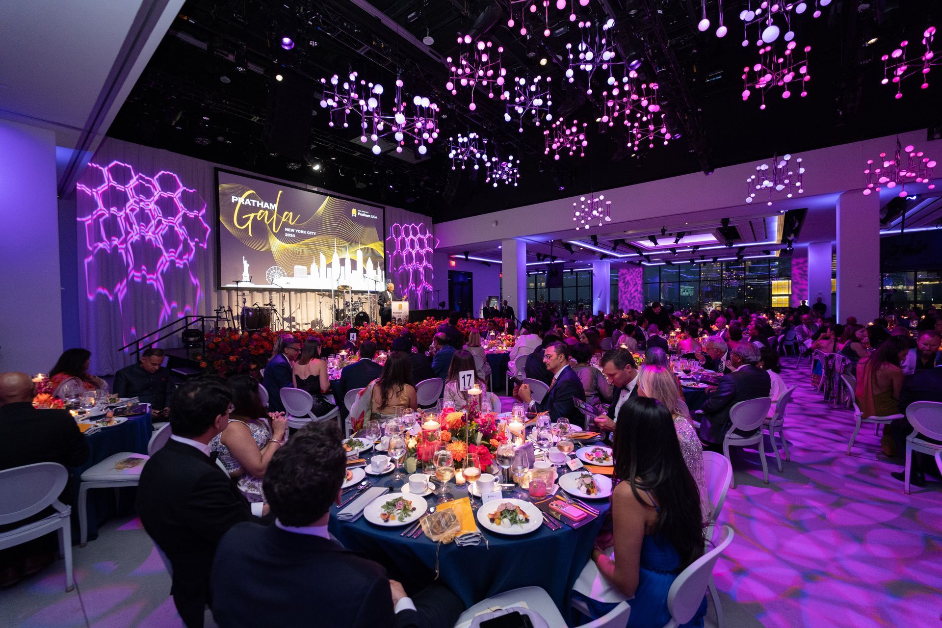 A large room with a circular dance floor and a chandelier hanging from the ceiling.