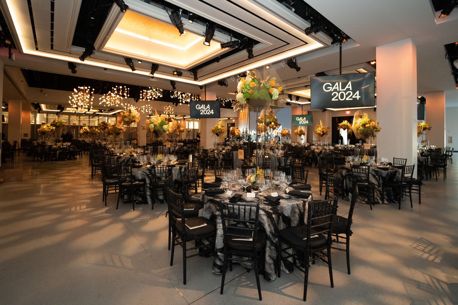 A large room with tables and chairs set up for a gala.