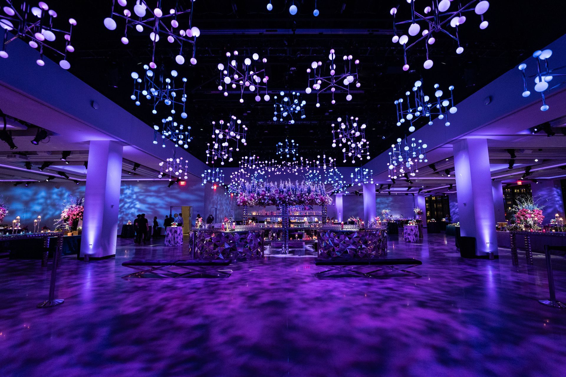 A large room with purple lights hanging from the ceiling