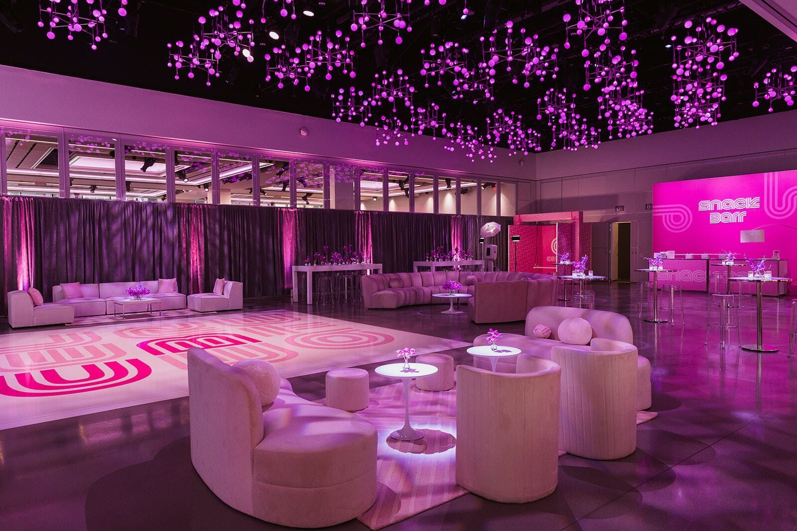 a large room with lots of furniture and purple lights on the ceiling .