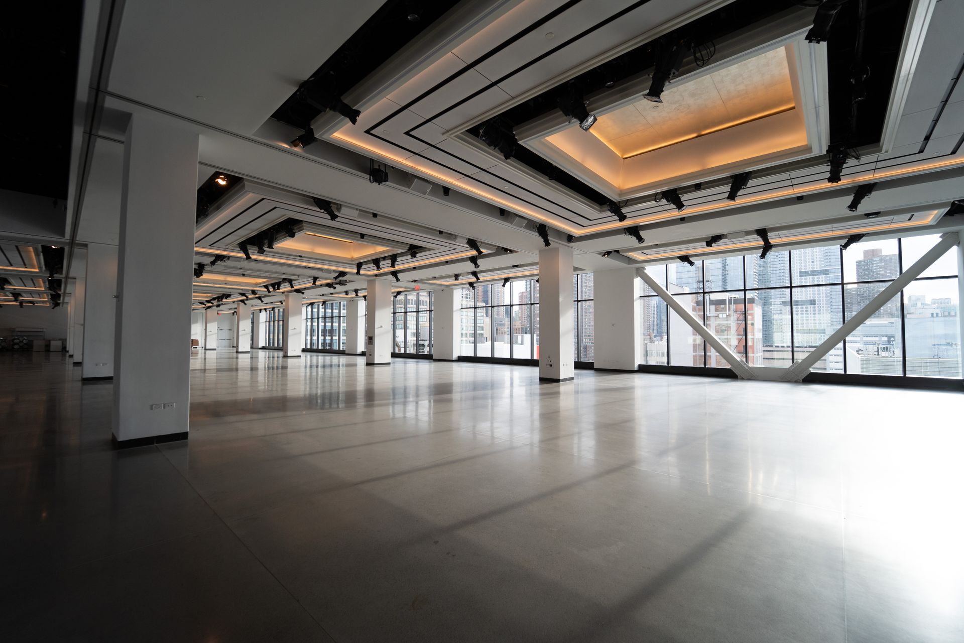 Large, empty event space with large windows and bright ceiling lights.