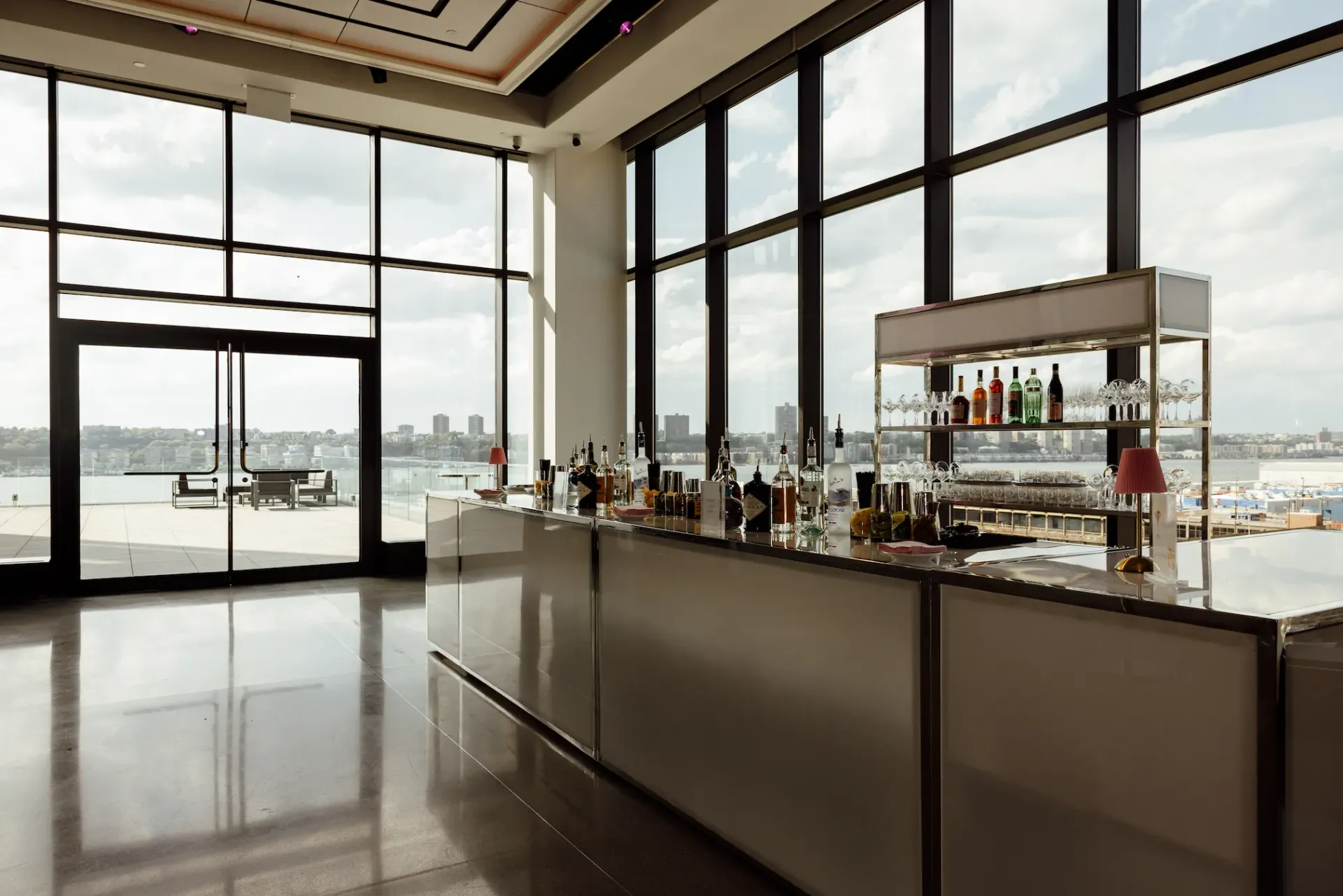 A large room with a bar and lots of windows.