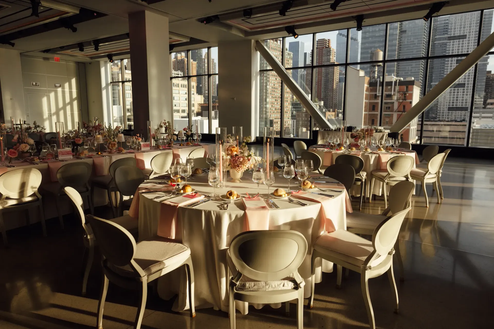 A large room with tables and chairs set up for a wedding reception.