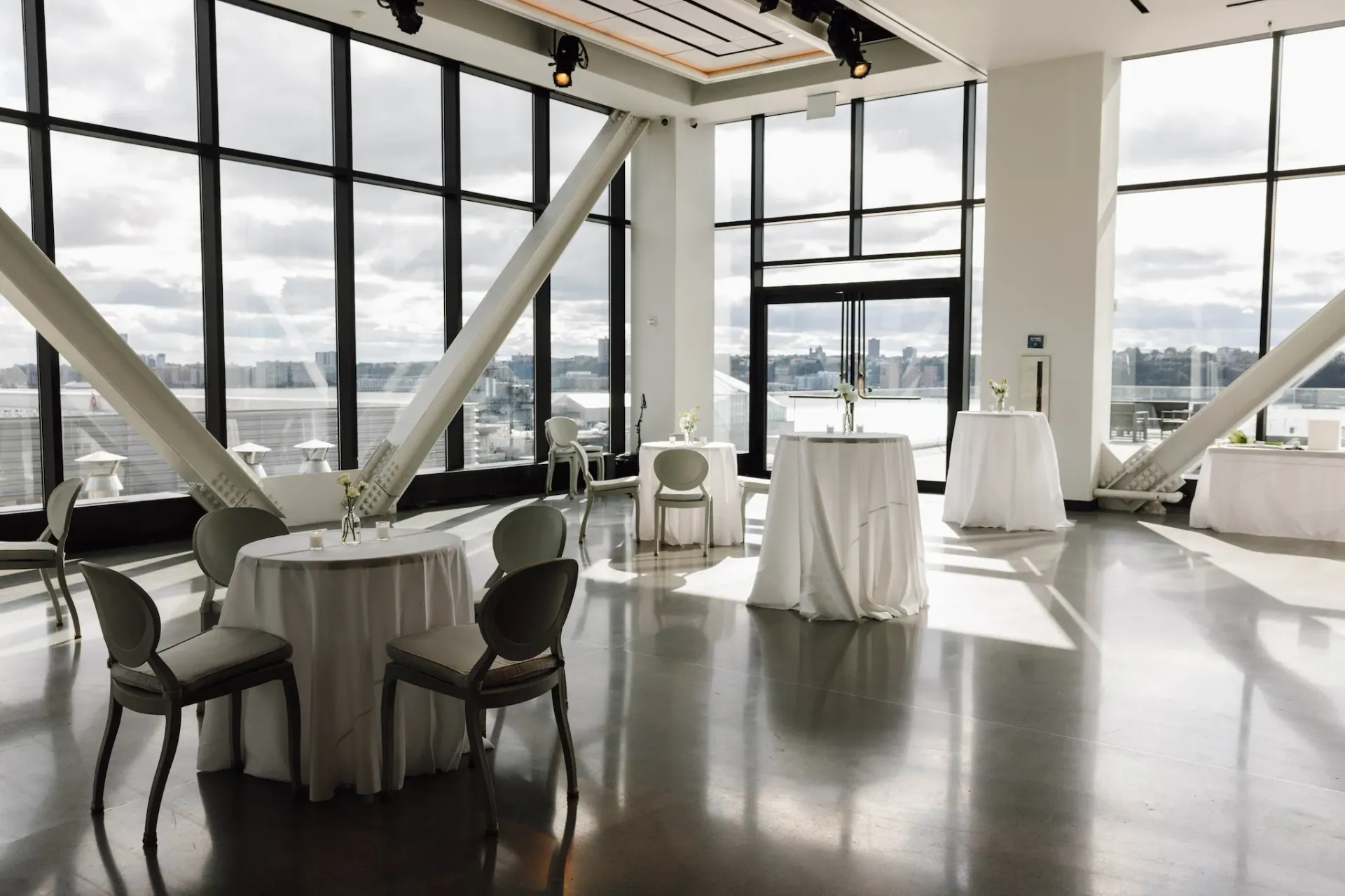 A large room with tables and chairs and a lot of windows
