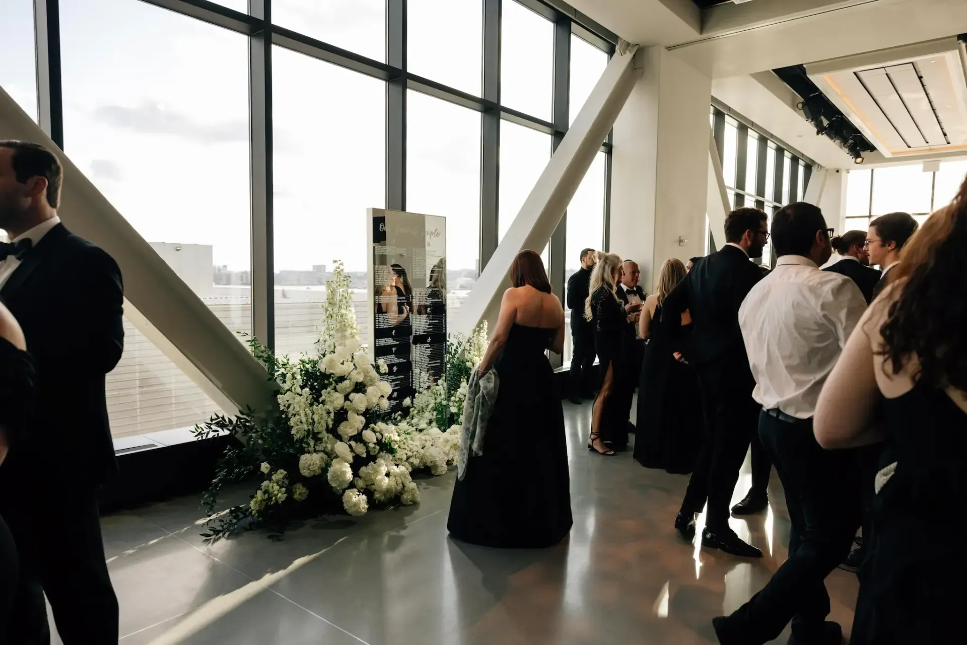 A group of people standing in front of a large window