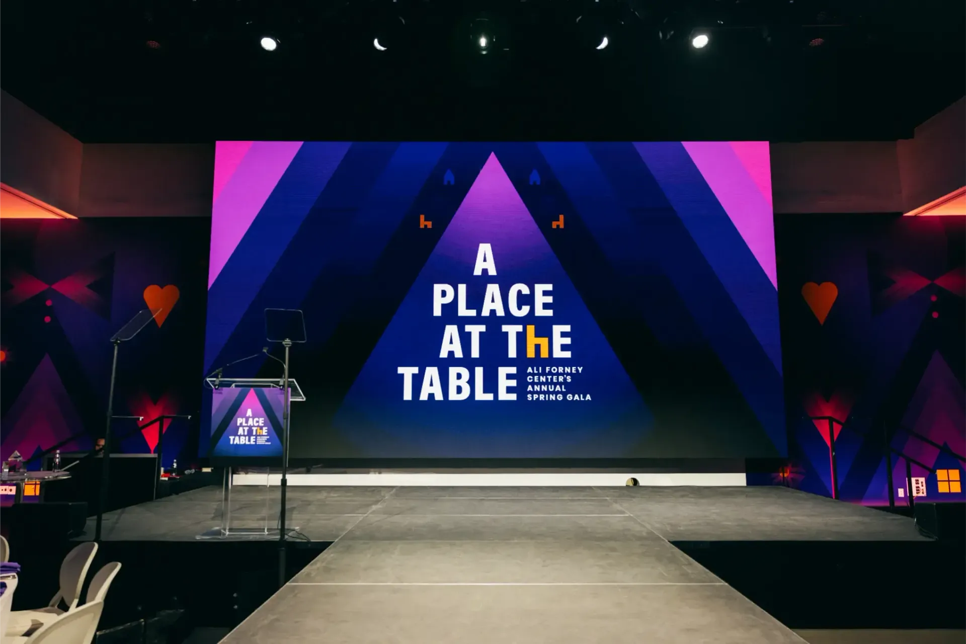 A stage with a large screen that says a place at the table