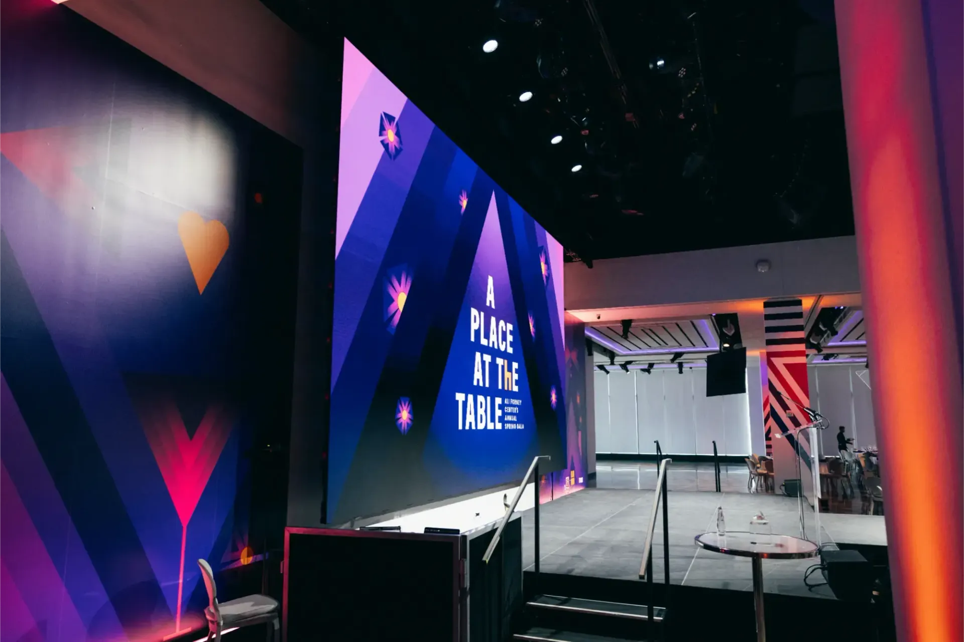 There is a large screen in the middle of the room that says a place at the table.